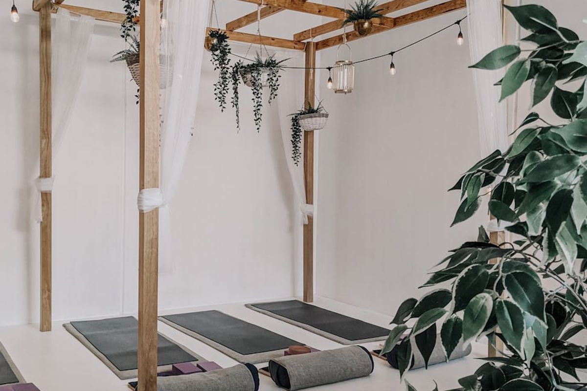 Serene yoga studio atmosphere with soft cyan lights and mats